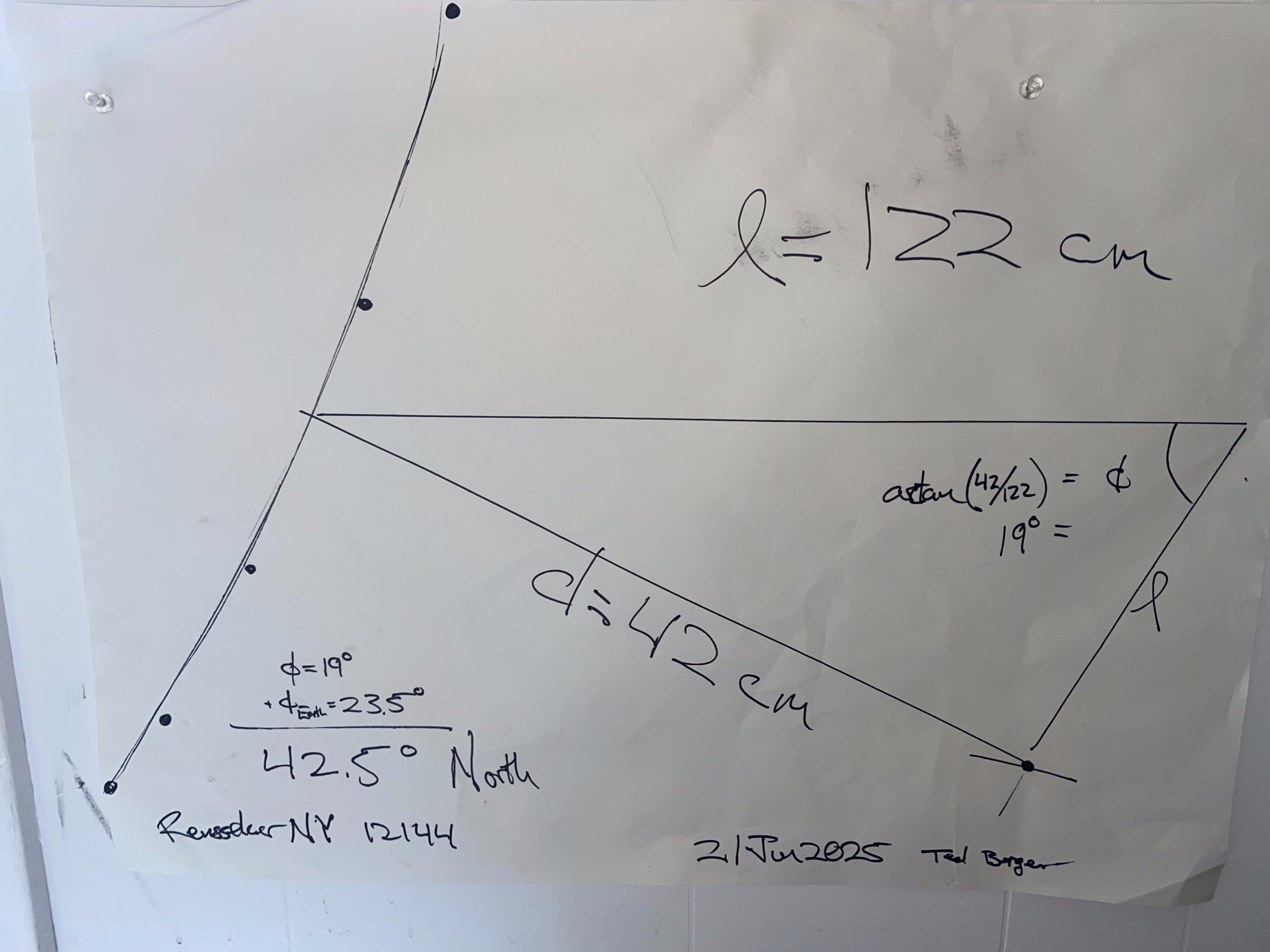 Gnomon shadow cast diagonally across a white paper at solar noon — Eratosthenes method