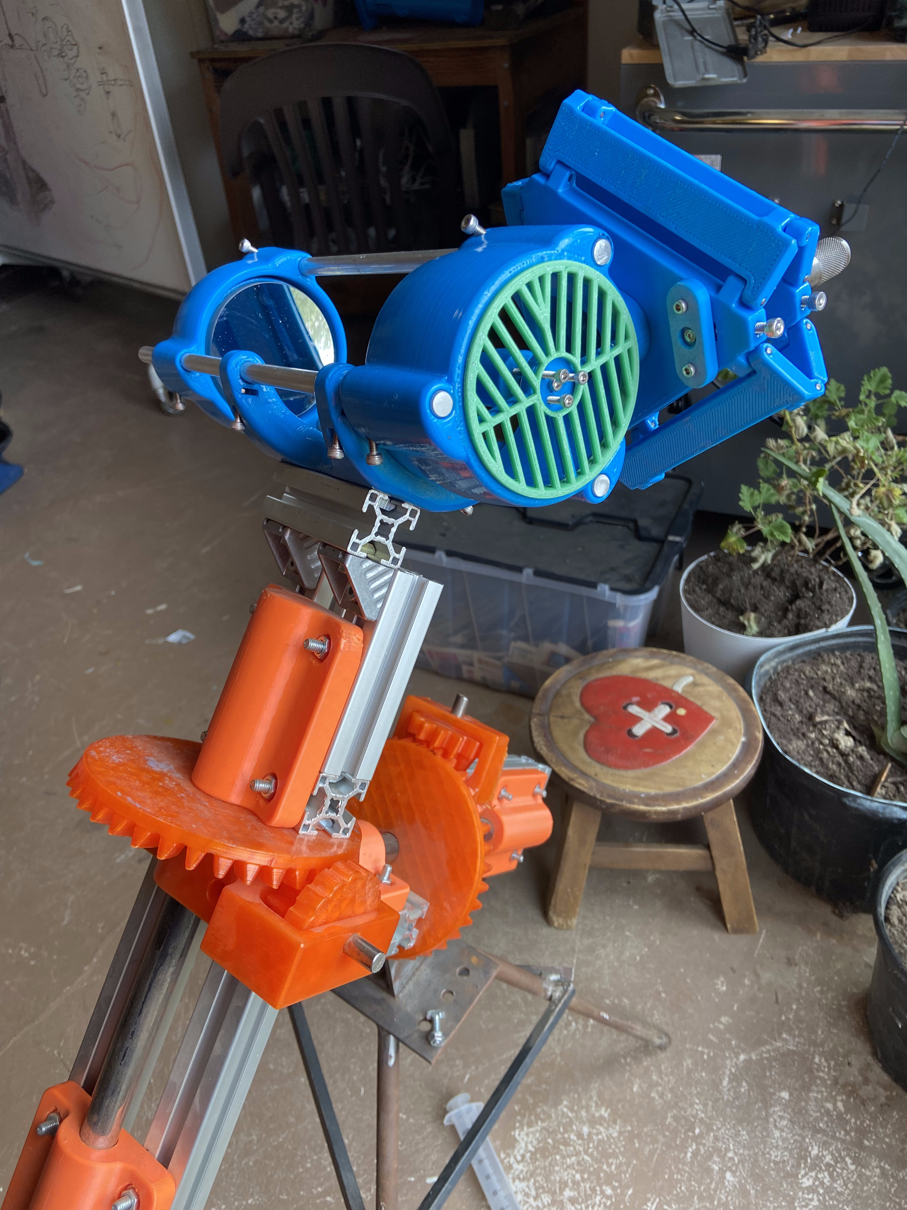 Blue telescope tube with green-bladed mirror fan cooler mounted to the equatorial base in the workshop