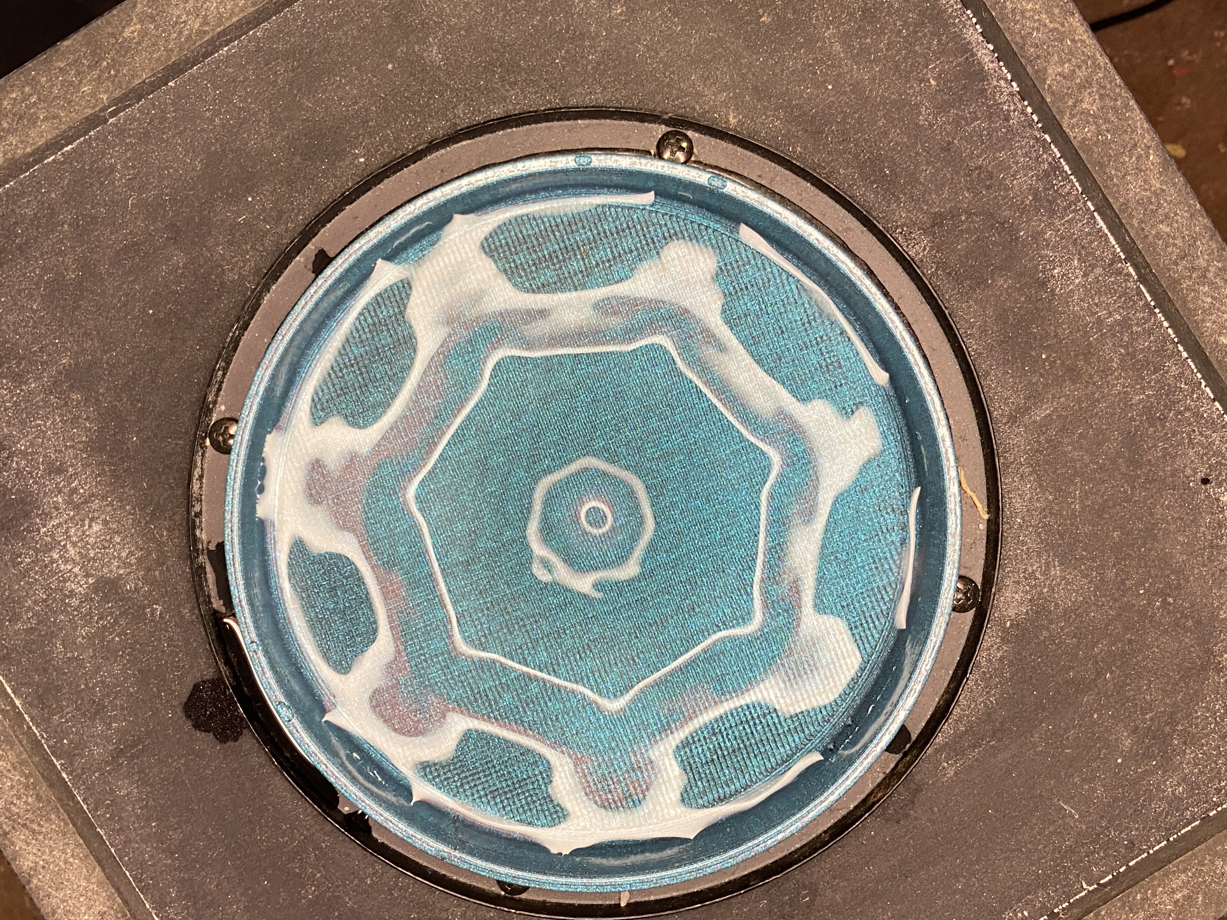 Chladni figure on a resonating plate showing octagonal standing wave pattern in blue powder