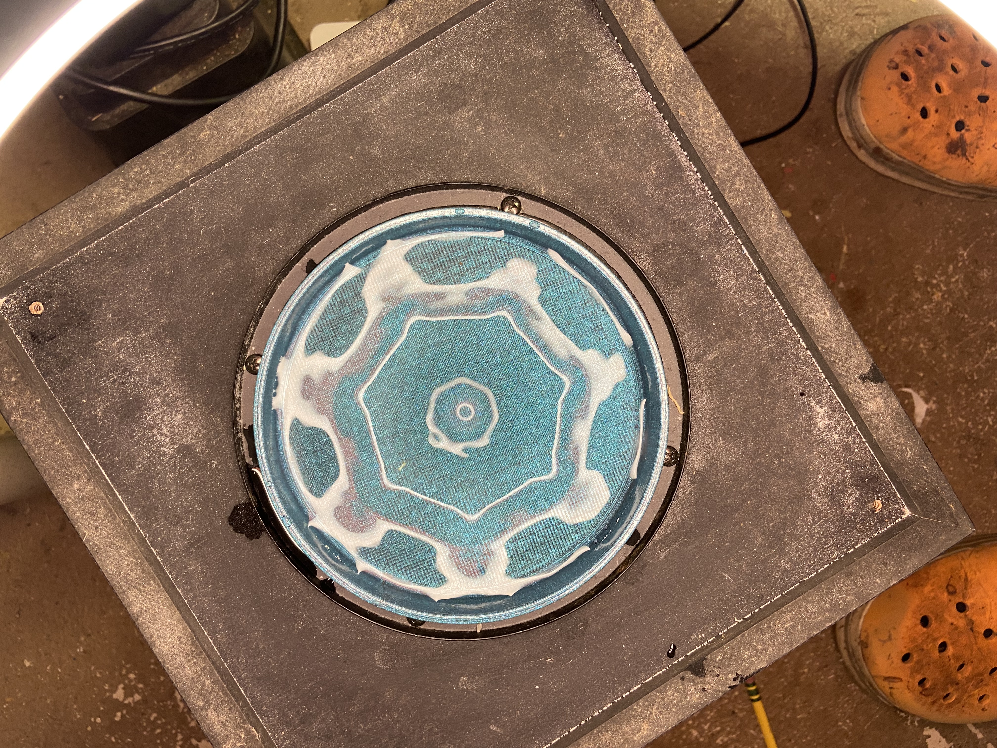 Wide view of blue octagonal Chladni figure in slurry — round plate and speaker rig visible