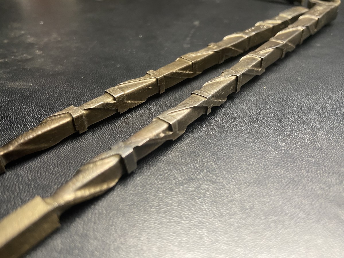 Two steel rods side by side showing etched vs unetched surface comparison