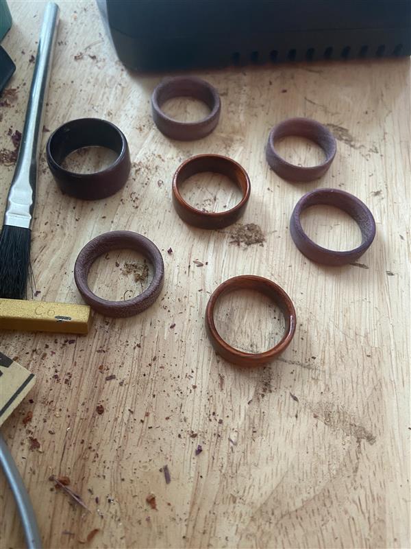 Six amber resin rings arranged on a workbench