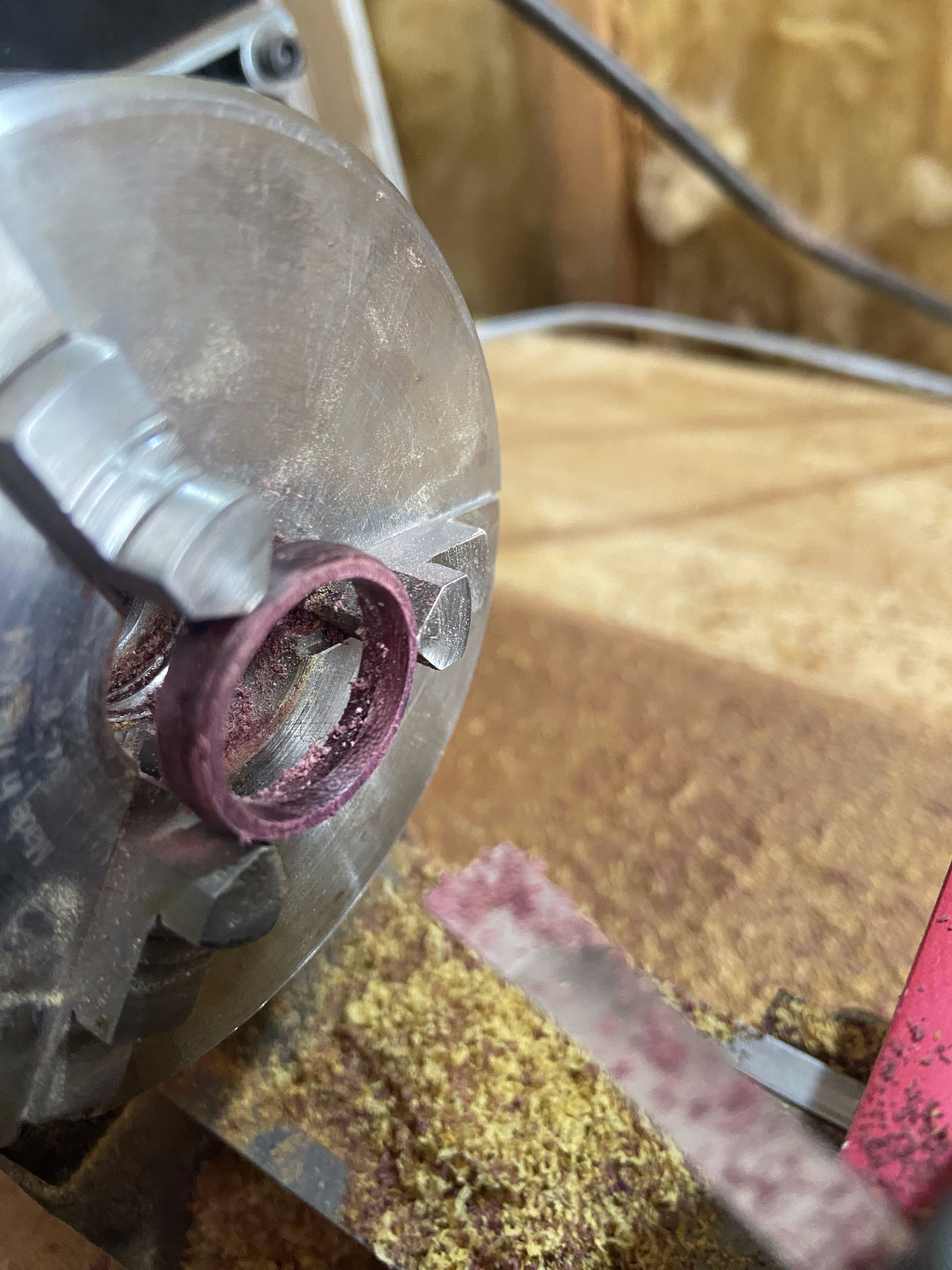 Purple heartwood ring being shaped on a lapidary grinding wheel