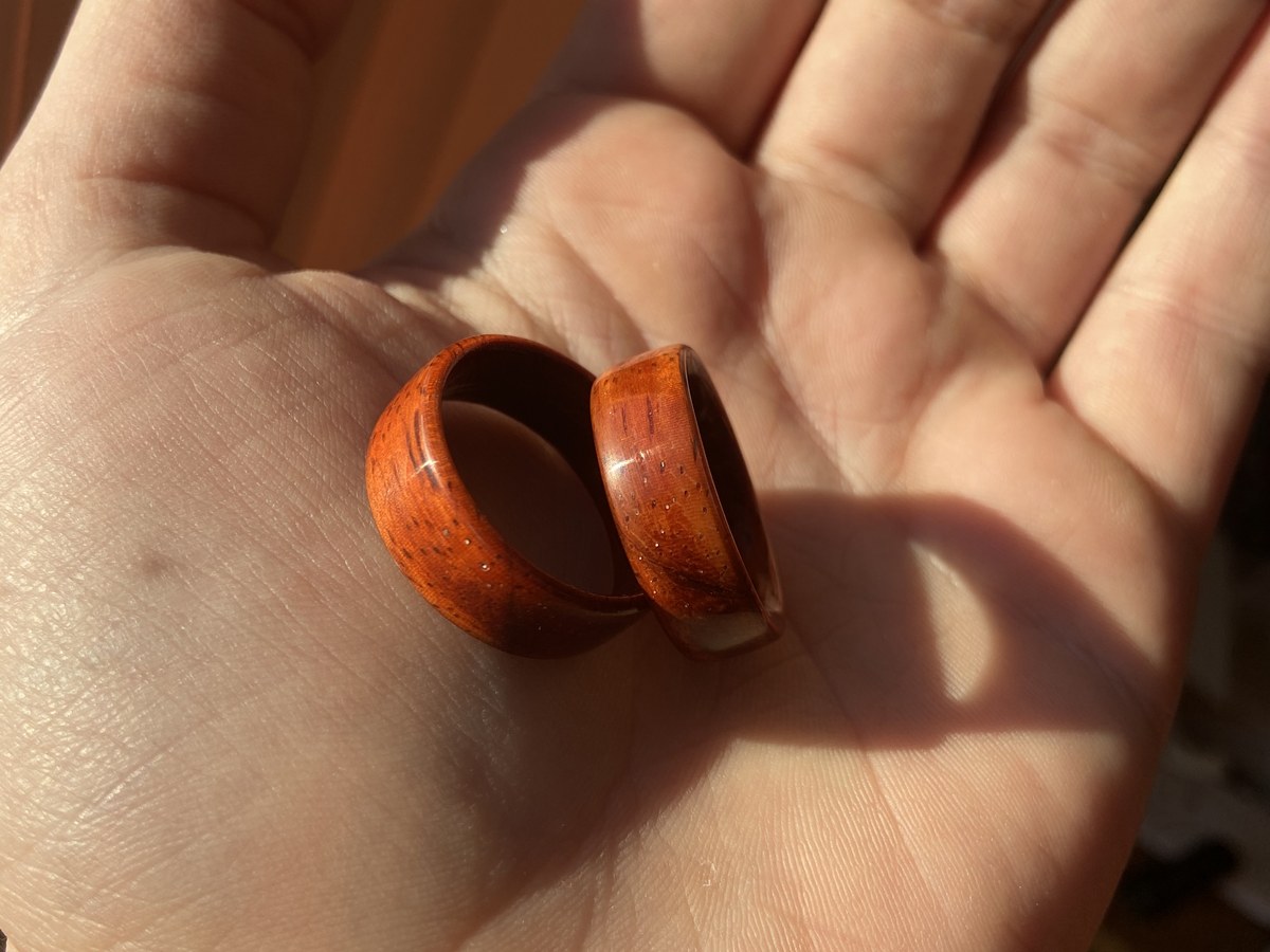 Two rings cupped in a hand, showing grain and color