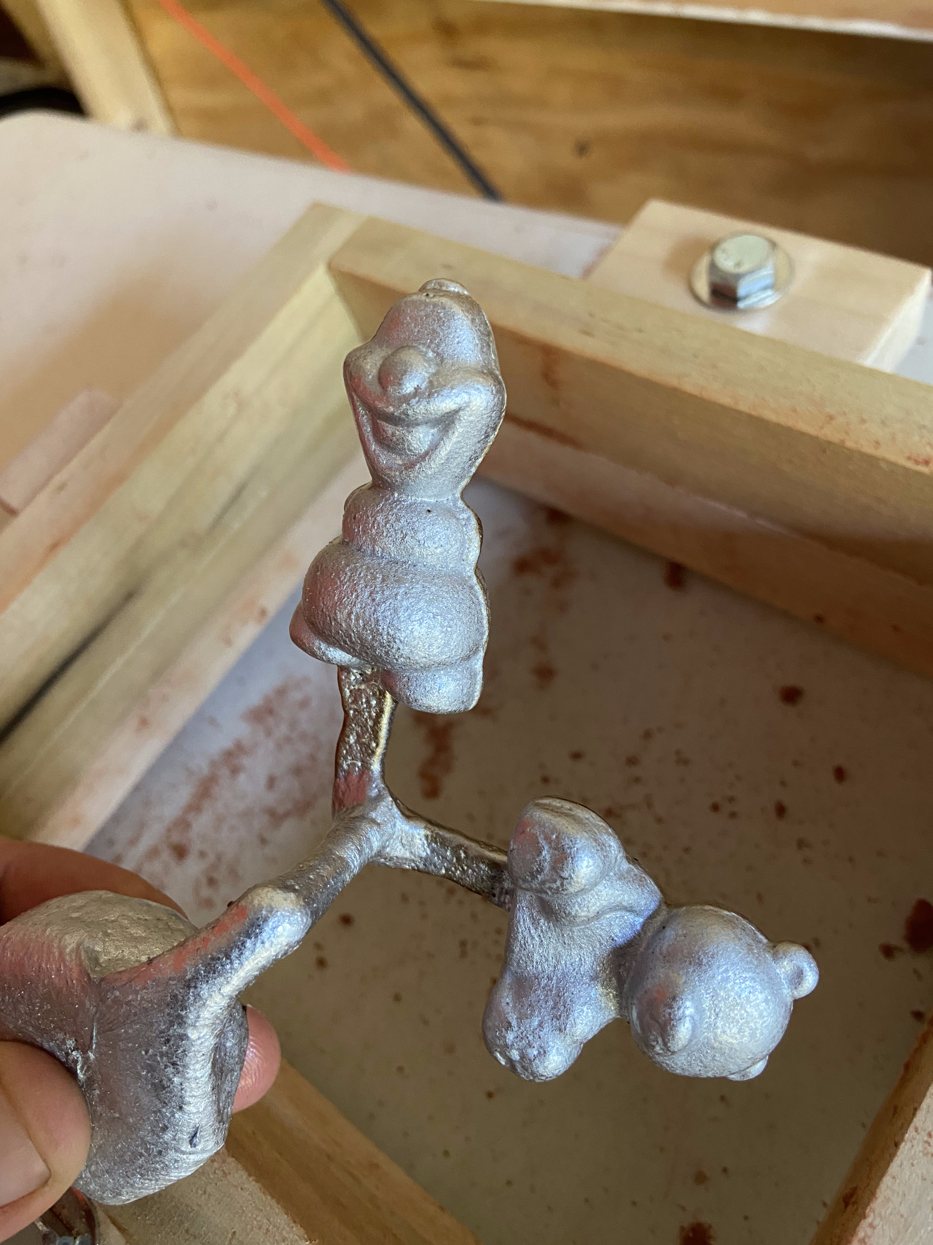 Cast aluminum figurines still attached to their sprue tree fresh from the mold